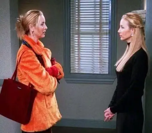 Twin sisters Phoebe Buffay and Ursula from Old Friends reunite in the hallway, with Phoebe on the left in an orange jacket and Ursula on the right in a black top. Twin sisters Phoebe Buffay and Ursula from Old Friends reunite in the hallway, with Phoebe on the left in an orange jacket and Ursula on the right in a black top.